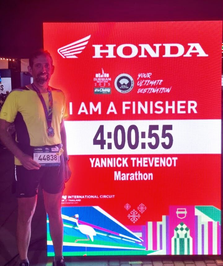 Runner posing next to his finish time display at the Buriram Marathon 2025.